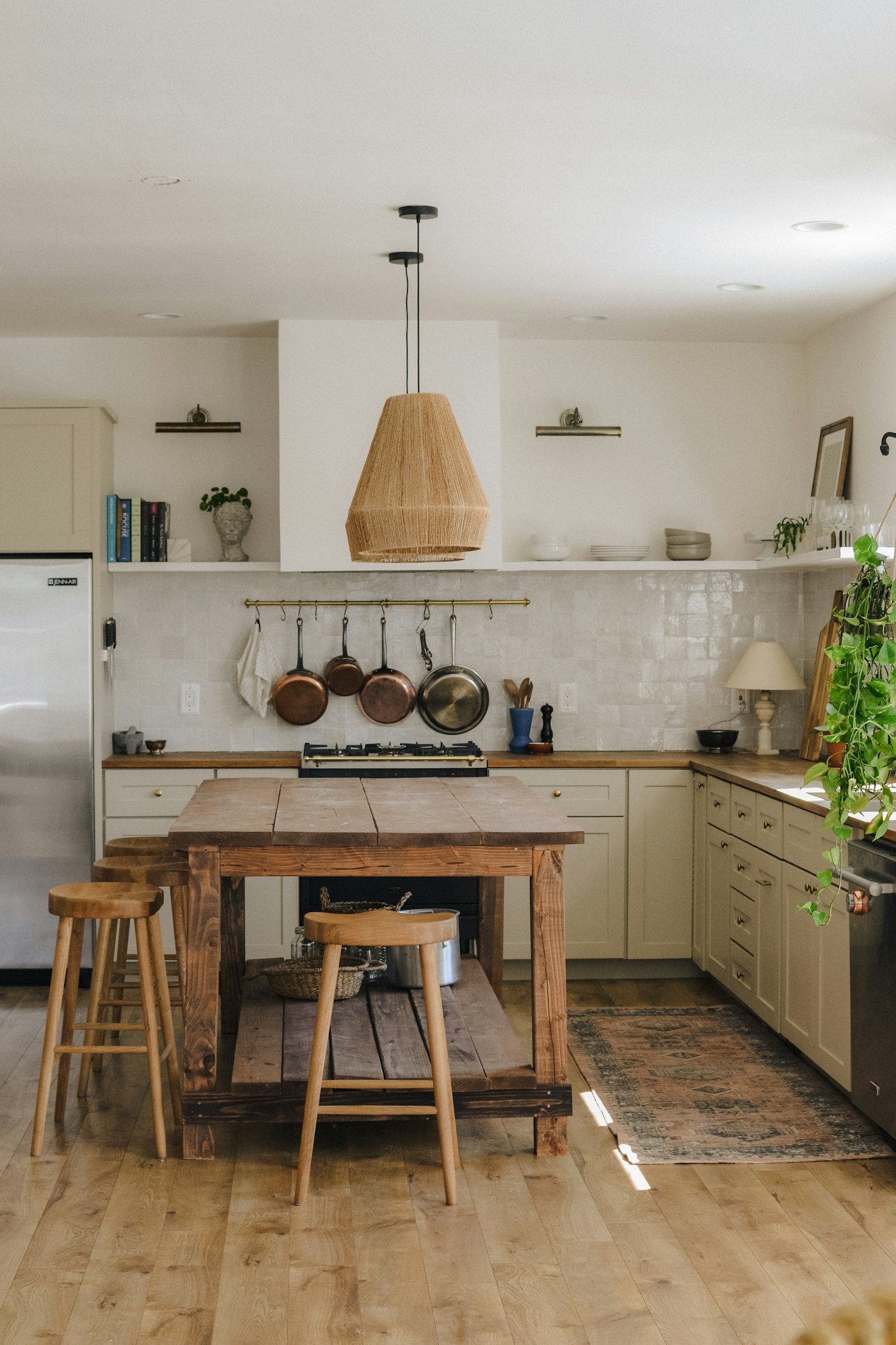 Upscale custom farmhouse kitchen with white cabinets and warm wood island